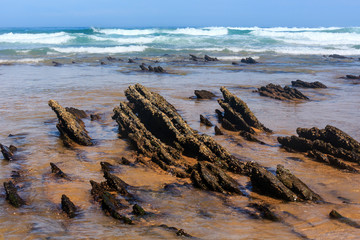 Fototapeta na wymiar Rock formations on sandy beach (Portugal).