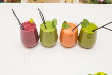 Red and green healthy smoothies on table.