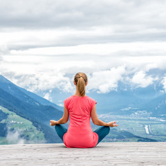 Fototapeta na wymiar young woman meditate on top of the mountain