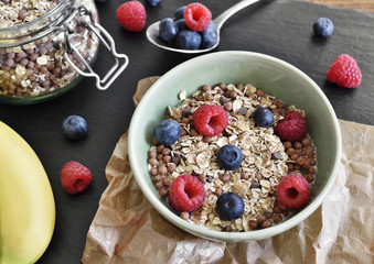 Delicious cereal breakfast with bowl and fresh fruits. Fresh blueberry and raspberry fruits, healthy eating scene.
