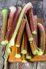 Fresh rhubarb stalks on wooden board for cutting