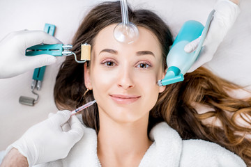 Beautiful woman with cosmetology tools lying on the medical couch. Facial treatment concept