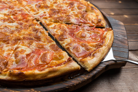 Pizza with Ham and Salami. Garnished with Olives