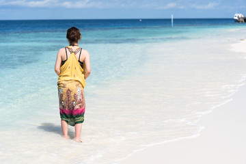 Naklejka premium 浜辺を歩く女性 砂浜 リゾート