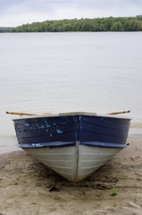 Obraz premium rustic blue boat on beach at river