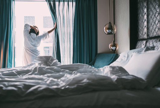 Woman meets rainy morning in luxus hotel room