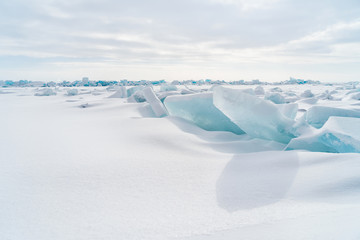 Blue frozen water covered with snow at Baikal lake during winter