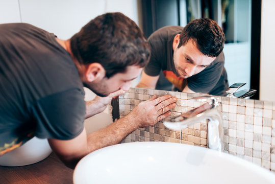 Industry Renovation Details. Construction Details With Handyman Or Worker Adding Mosaic Ceramic Tiles On Bathroom Walls