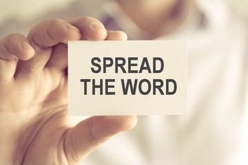 Businessman holding SPREAD THE WORD message card