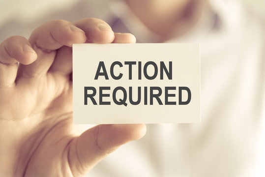 Businessman holding ACTION REQUIRED message card