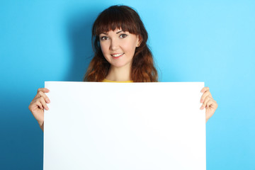 Fototapeta premium girl holding a big white sheet of paper