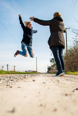 Adult daughter jumps into the arms of his mother, arms widespread, rural idyll, a beautiful sunny day