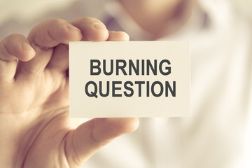 Businessman holding BURNING QUESTION message card