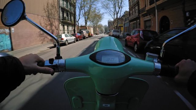 Driving innovative electric scooter through streets in industrial neighbourhood at summer sunny day, pov view on action cam