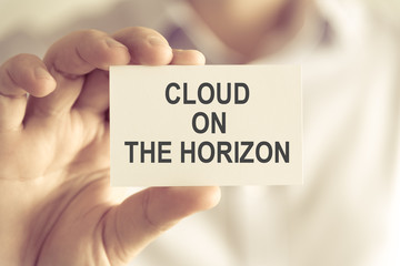 Businessman holding CLOUD ON THE HORIZON message card