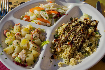 Trittico di antipasti di mare serviti su un piatto bianco con divisorio.