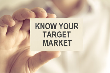 Businessman holding KNOW YOUR TARGET MARKET message card