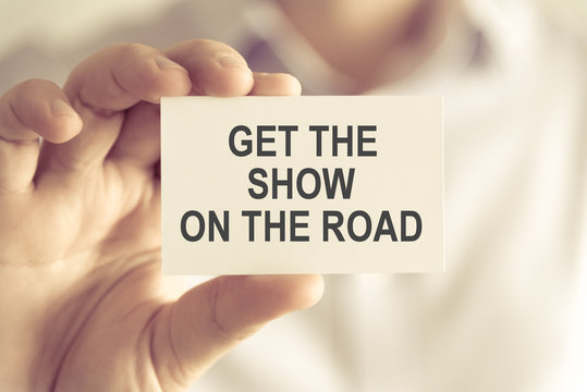 Businessman Holding GET THE SHOW ON THE ROAD Message Card