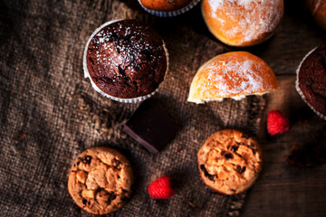 Fresh chocolate muffins and cookies closeup. horizontal view from above