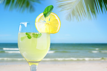 Fresh lemon juice and blur beach background.