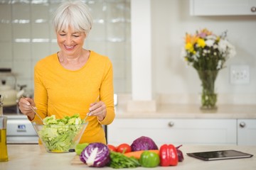 Senior woman preparing vegetable salad