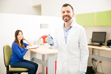 Fototapeta premium Happy doctor with a blood test tube