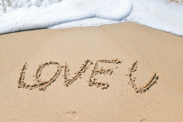 Love U sign on the sand beach copy space texture background
