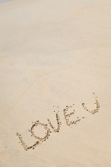 LOVE U sign on wet sand beach background