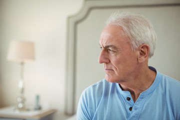 Fototapeta premium Thoughtful senior man sitting in bed room