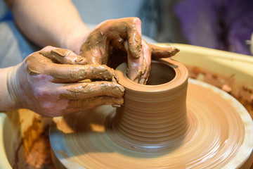 potter makes a pot of clay, working on the potter's wheel.
