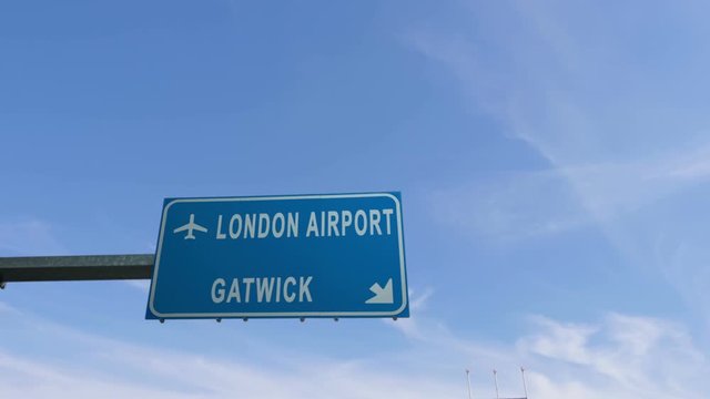 london gatwick airport sign airplane passing overhead
