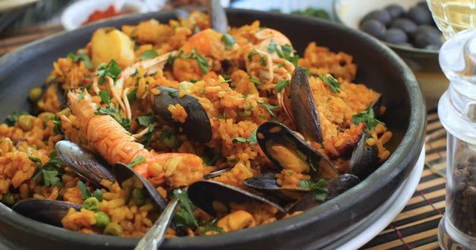 Dolly close up push in view of a Spanish seafood paella: mussels, king prawns, langoustine, haddock