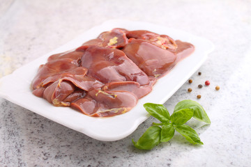 Chicken raw liver in a white plate on a white background