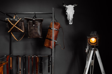 leather handbags and leather belts near the wall