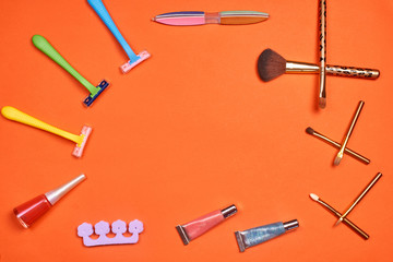 Flat lay, top view feminine table desk isolated on white. Workspace with cosmetics, phone, glasses, lipstick, nail lacquer, watches, mascara and eyeshadow in gold. Golden and black tones.