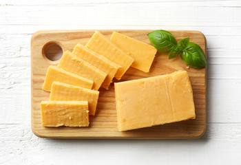 Piece and slices of cheddar cheese - obrazy, fototapety, plakaty