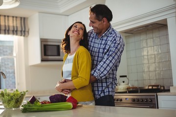 Obraz premium Couple embracing each other in kitchen