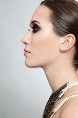 Profile portrait of young beautiful woman with smoky eyes