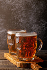 Cold beer in glass with chips on a dark background.
