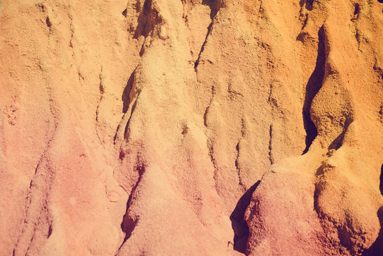 Closeup on red rock wall with sunny outdoors background