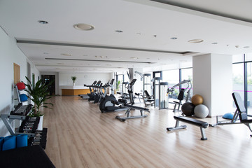 Big light gym with sports equipment in hotel
