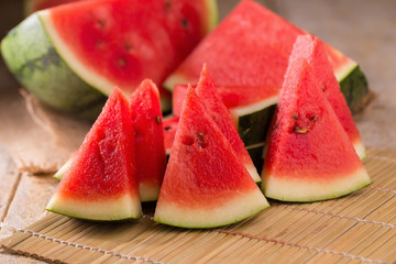 watermelon and watermelon pieces in a wooden background