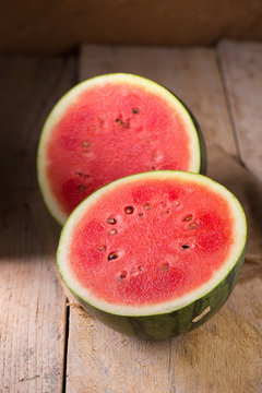 watermelon and watermelon pieces in a wooden background