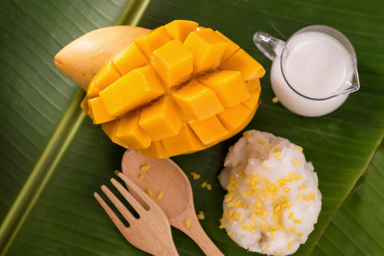 thailand dessert by sweet mango and sticky rice on banana leaf.