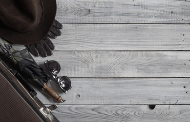 Man's hat and retro accessories for travel on a white painted wo
