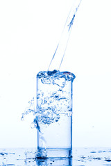 Water pours into the glass, monochromatic background, studio light