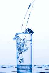 Water pours into the glass, monochromatic background, studio light
