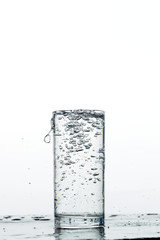 Water pours into the glass, monochromatic background, studio light