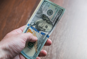 American money in a hand on a brown background. close-up