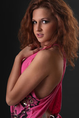 Naklejka premium beautiful woman in pink blouse on black background